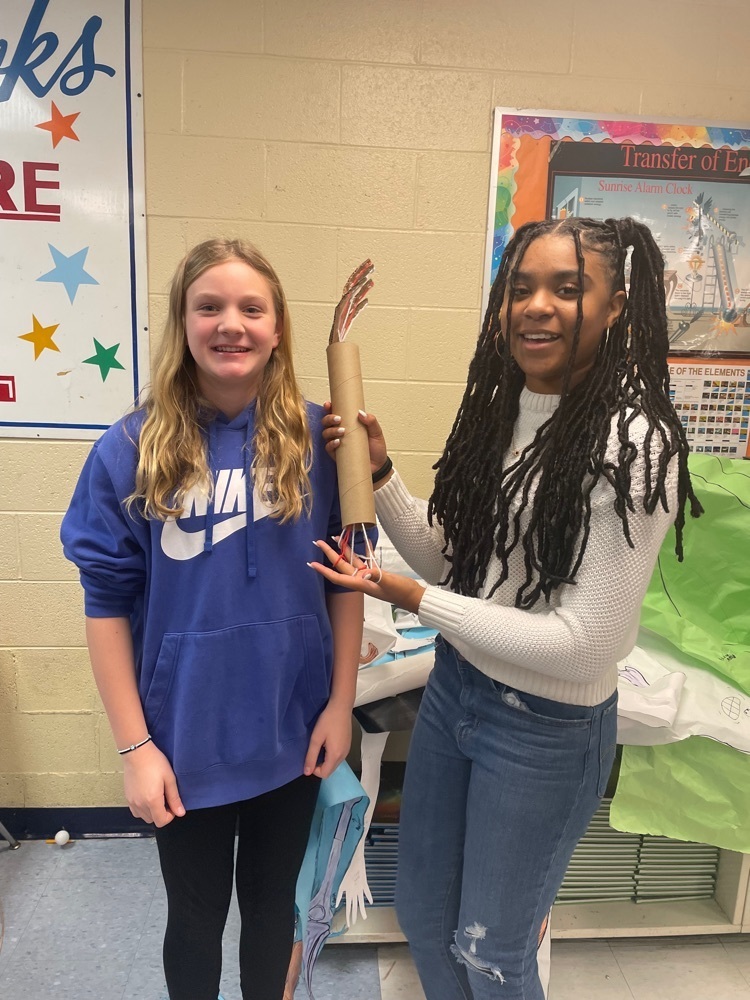 students in science class holding prosthetic arm